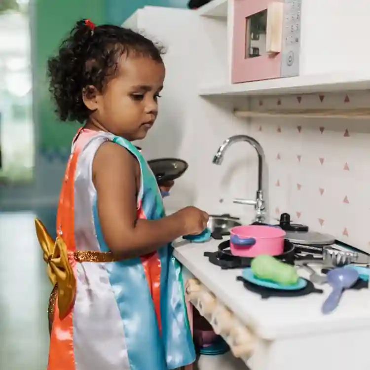 Image of a young child playing with some kitchenette toys | Toys Category Image